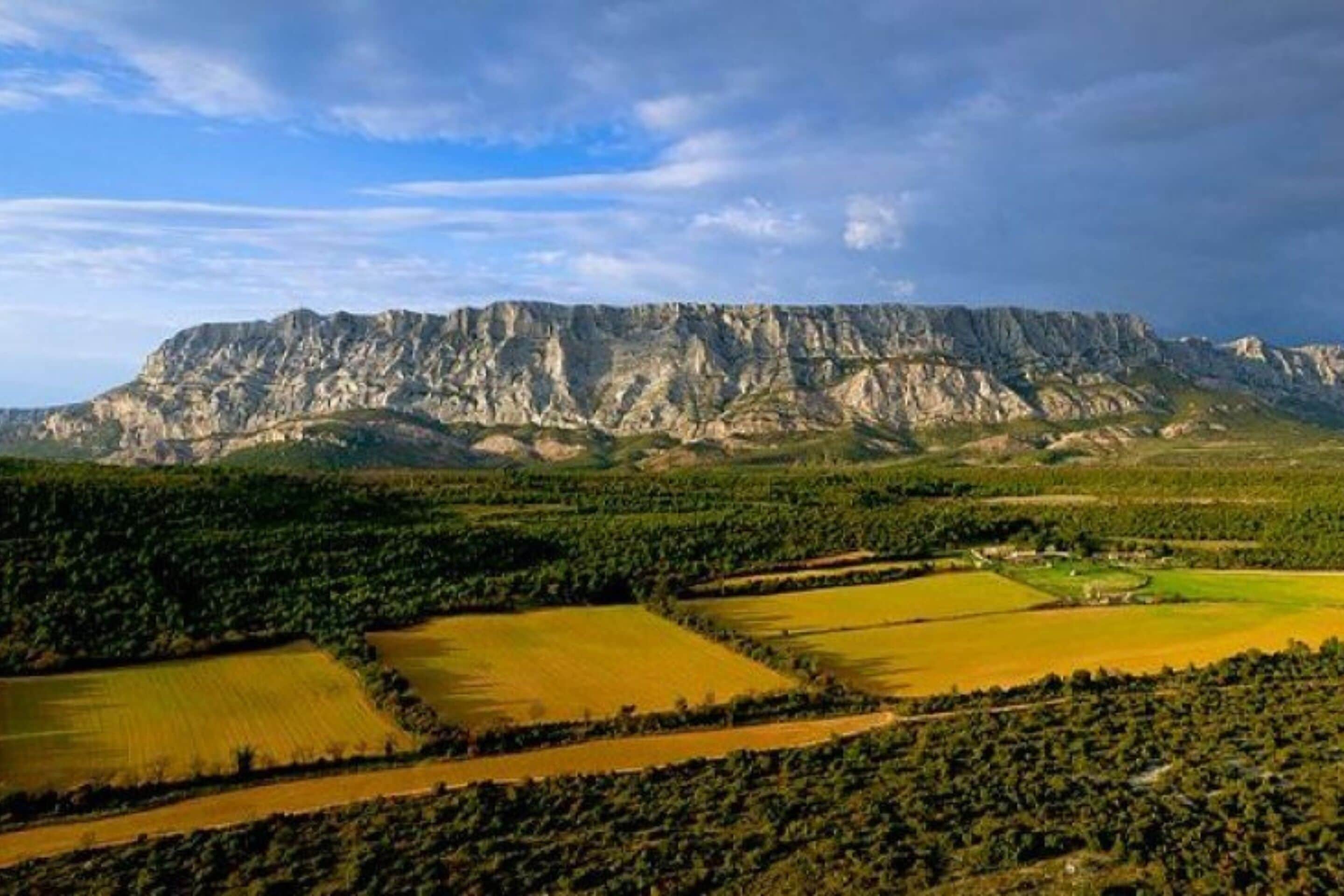 A mountainous landscape with fields and a clear sky.