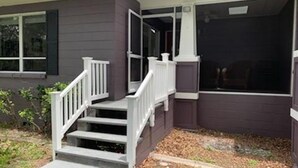 A residential house with a front porch, a staircase, and a large window. - Lakefront VERY PRIVATE Guest House with Gorgeous Lake Views!  2-Bed, 2-Bath (Brandon)