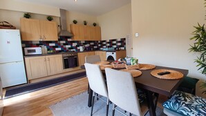 Une cuisine moderne avec des meubles en bois, un four à micro-ondes et un lave-linge.