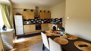 Une cuisine compacte avec des meubles en bois, un four à micro-ondes, une cuisinière et un lave-linge.