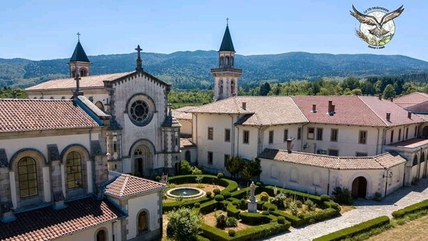 A historical building complex with multiple structures, including a church with a bell tower and a central courtyard with a fountain. - Le Vie Mediterranee (Torre di Ruggiero)