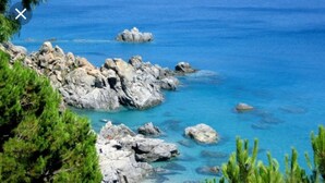A rocky coastline with clear blue waters and green vegetation. - Le Vie Mediterranee (Torre di Ruggiero)