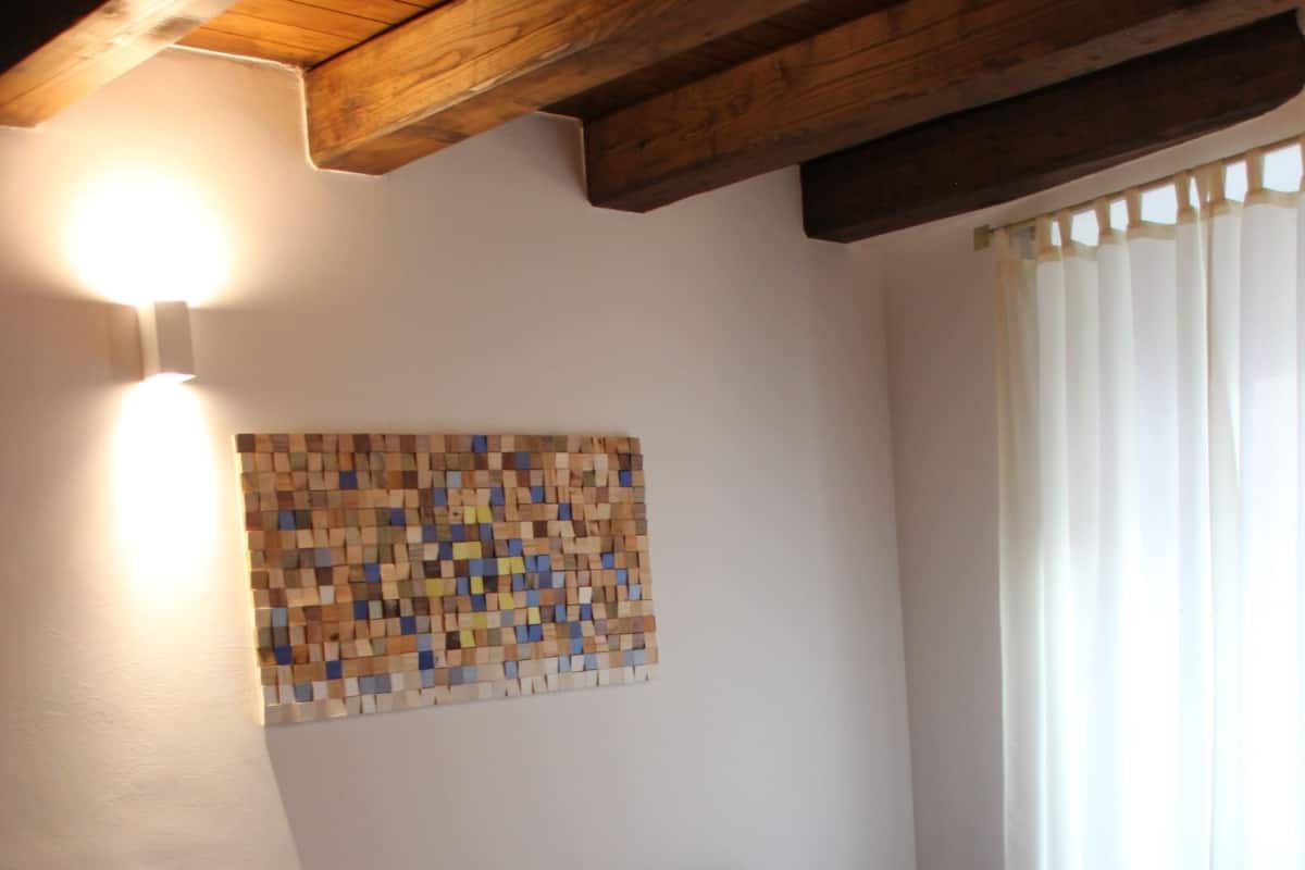 A living room with a blue sofa, a table with a decorative object, and a wall-mounted light fixture.