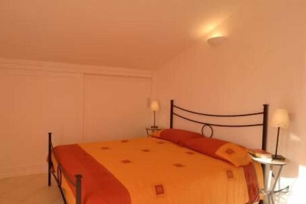 Une chambre à coucher avec un lit, deux lampes de chevet et une porte fermée.