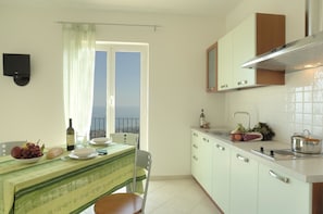 Appartement, balcon, vue mer (Basilico) | Cuisine privée | Grand réfrigérateur, micro-ondes, four, plaque de cuisson