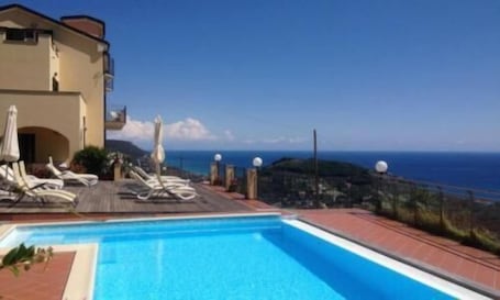 Una piscina al aire libre de temporada, sombrillas