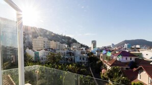 A balcony with a clear view of a residential area, including houses and a hill in the background. - O Dau Day Boutique Hotel (Ho Chi Minh City)