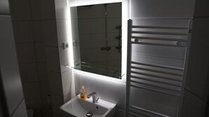 A bathroom with a white sink, a glass shelf, and a towel rack. - 364.Berlin (Berlin)