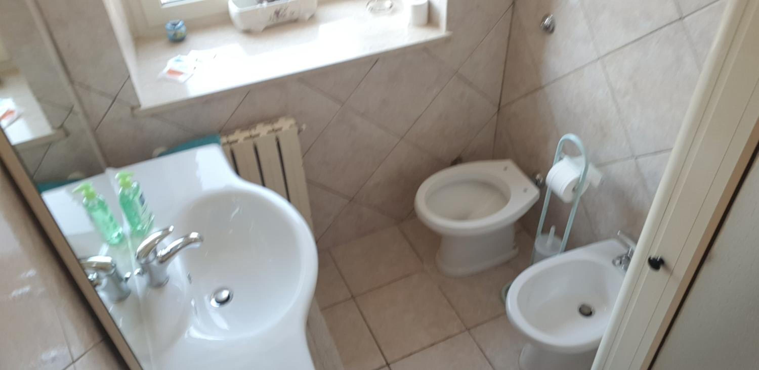 Ένα μπάνιο με νιπτήρα, μπιντέ και τουαλέτα.