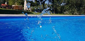 Una piscina con agua azul cristalina y burbujas que suben a la superficie.