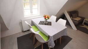 Uma área de refeições com uma mesa, cadeiras e uma janela.