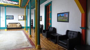 A room with a sofa, two armchairs, a small table, and a painting on the wall. - Hotel Jardin es Tuyo (Puerto Guzmán)