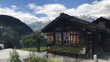 Ein rustikales Holzgebäude mit einem Schild, auf dem "Oberstollen" steht. Es zeigt traditionelle alpene Architektur mit einem geneigten Dach und Holzhörnchen.