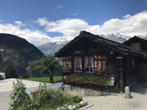 Ein rustikales Holzgebäude mit einem Schild, auf dem "Oberstollen" steht. Es zeigt traditionelle alpene Architektur mit einem geneigten Dach und Holzhörnchen.