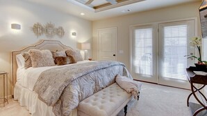 Ein Schlafzimmer mit einem Bett, einer Bank, einem Deckenventilator und zwei Fenstern mit Jalousien.