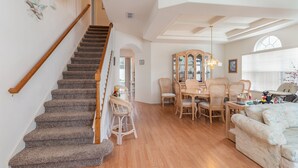 A staircase with wooden handrails leading to a dining area with a wooden table and chairs. - SEASONAL LOW RATES!!!Located in Disney's backyard- WITH PRIVATE POOL!!! (Clermont)