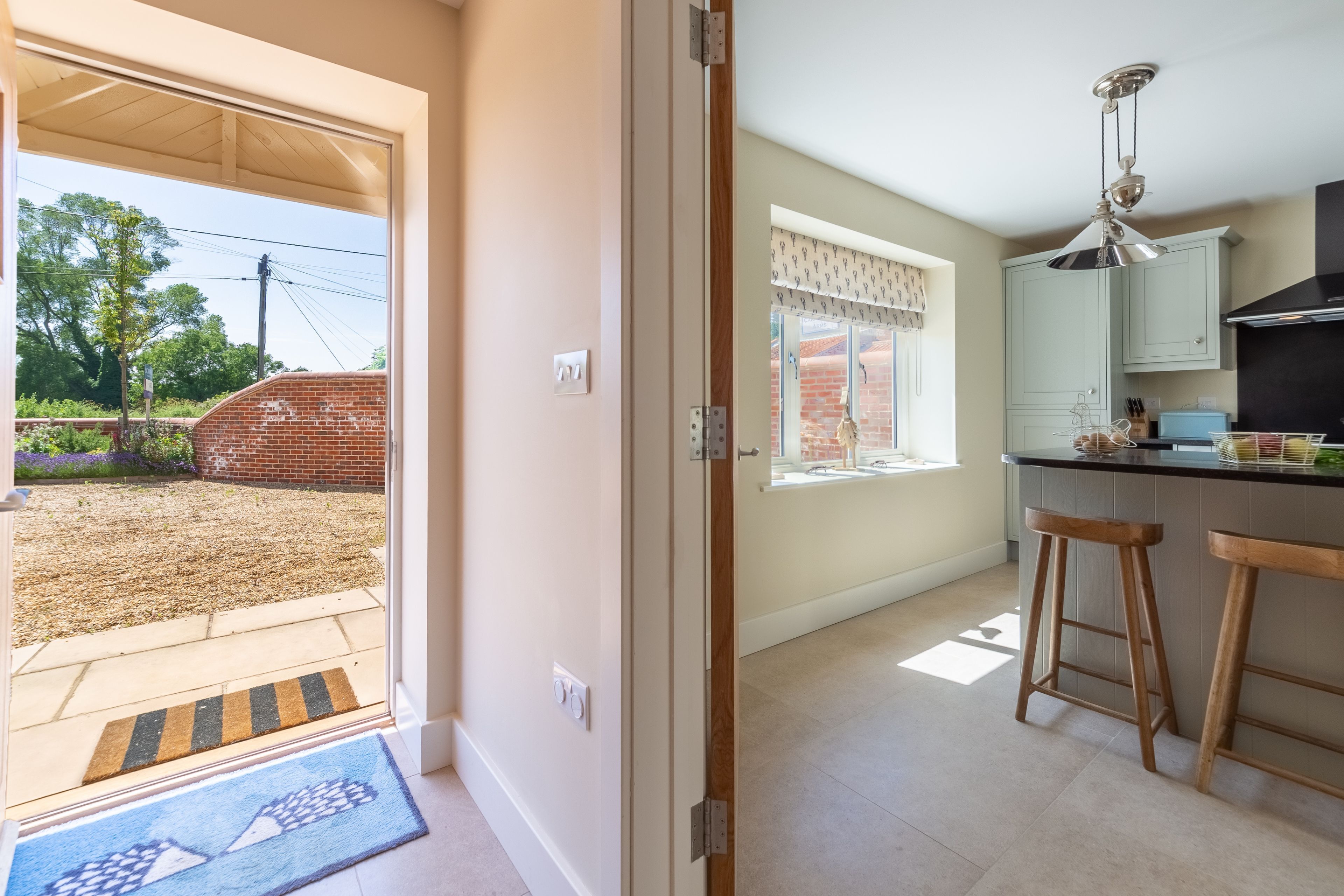 Eine Küche mit einer großen Kochinsel, Holzstühlen und einer hängenden Leuchte.