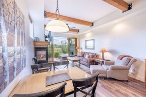 A cozy living room with a fireplace, a dining table, and comfortable seating.
