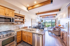 A modern kitchen with a gas stove, microwave, and dishwasher.