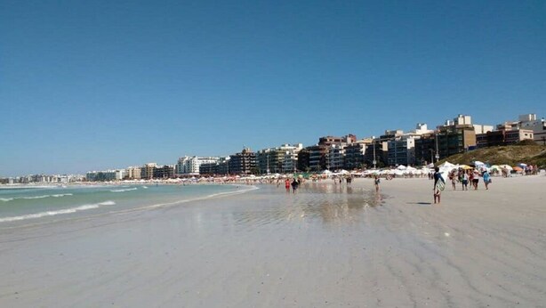 A wide sandy beach with buildings in the background. - There's still time to make your reservation for Carnival, excellent apartment, take advantage! (Cabo Frio)