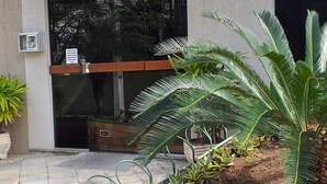 The entrance to Ville D'Avray with a modern design, featuring a sign above the door and a well-maintained garden with various plants. - There's still time to make your reservation for Carnival, excellent apartment, take advantage! (Cabo Frio)