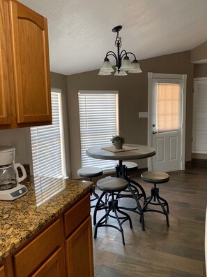 Enjoy cooking in this fully equipped kitchen with a coffee maker, dining table, and chandelier.