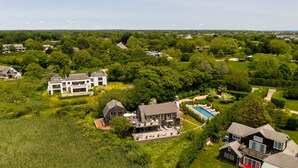 Vue aérienne d’un quartier résidentiel avec de nombreuses maisons, une piscine et des pelouses bien entretenues.