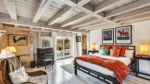 Une chambre spacieuse avec un grand lit, un bureau et une vue sur l’extérieur grâce à une porte coulissante.