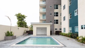 A swimming pool in a courtyard surrounded by buildings.