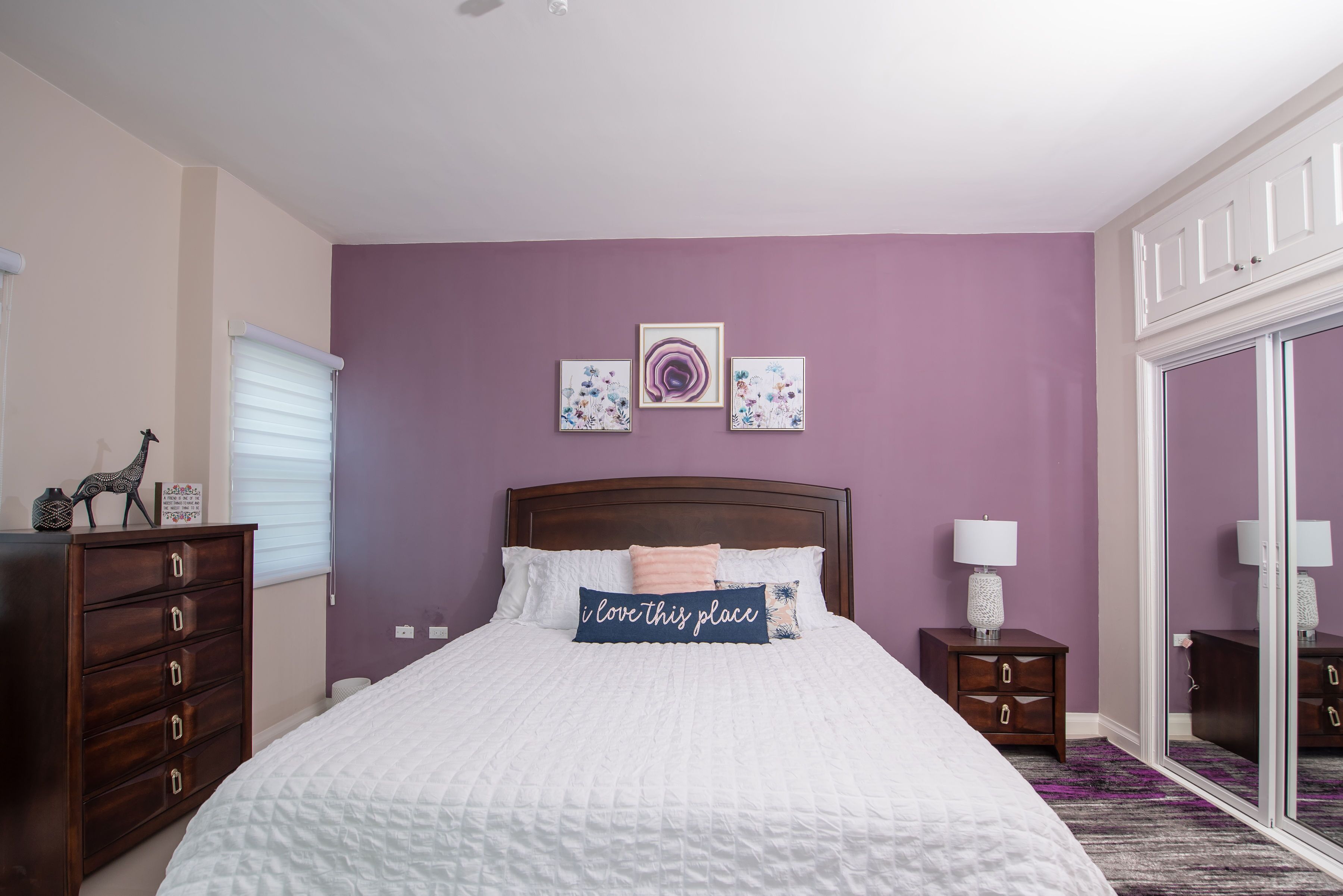 Ein Schlafzimmer mit Bett, Schminktisch, Nachttisch und einer Tür zum Badezimmer.