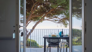 Un balcone con un tavolo apparecchiato per due, con vista su un corpo d'acqua.