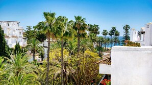 A coastal town with white buildings, palm trees, and a clear blue sky. - 1081 Luxurious Beachfront Penthouse with Jacuzzi (Marbella)