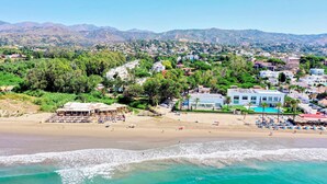 A coastal town with a beach, houses, and mountains in the background. - 1081 Luxurious Beachfront Penthouse with Jacuzzi (Marbella)