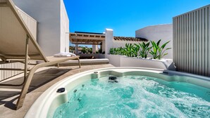 A hot tub with a clear view of the sky, a lounge chair, and a pergola structure. - 1081 Luxurious Beachfront Penthouse with Jacuzzi (Marbella)