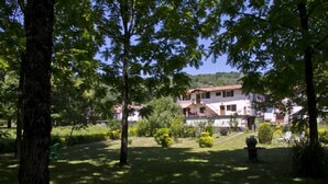 A two-story building with a red-tiled roof, surrounded by lush greenery and trees. - RURAL HOUSE ARTXEA 2PLTA (Mardea)