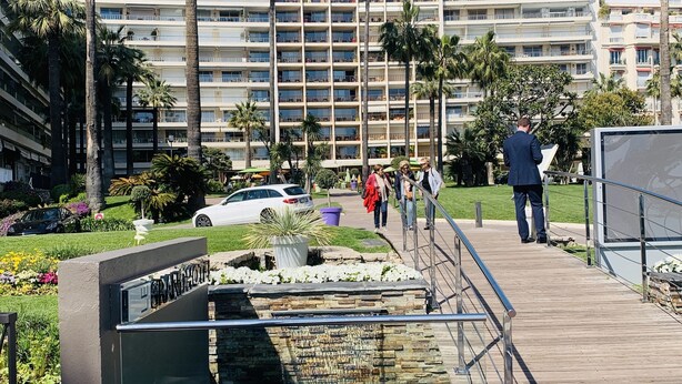 A Grand Hotel with a pool area, palm trees, and a wooden deck. - Studio with terrace on the Croisette - Residence du Grand Hotel (Cannes)