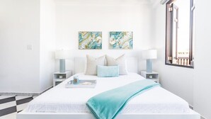 A modern bedroom with a large bed, two bedside tables, and artwork on the wall. - Mint Suite | 1BR Apt at Old San Juan (San Juan)
