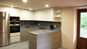 A modern kitchen with stainless steel appliances, a marble countertop, and built-in cabinets. - ARTXEA RURAL HOUSE 1PLTA (Mardea)