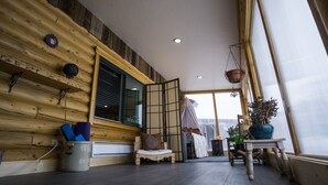 A log cabin interior with a bed, a chair, a table, and a window with a view. - Modern log home with a view of the Tetons! (Victor)