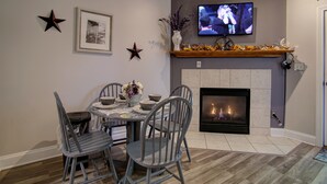 A dining area with a fireplace, a television mounted above it, and a star decoration on the wall. - INDOOR POOL! CLOSE TO DOLLYWOOD!! (Pigeon Forge)