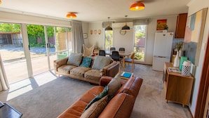 A spacious living area with a sofa, a dining table, and a kitchen area. - Rejuvenate on Rata · Rejuvenate on Rata, Twizel FREE WIFI (Twizel)