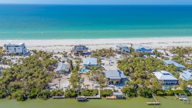 An aerial view of a coastal residential area with multiple houses, a beach, and a marina. - Family Tides: Beach Pool and Dock..This 5 Bedroom beach house has it all! (Placida)