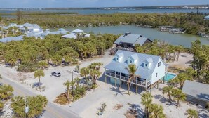 A coastal property with multiple buildings, a swimming pool, and a marina. - Family Tides: Beach Pool and Dock..This 5 Bedroom beach house has it all! (Placida)