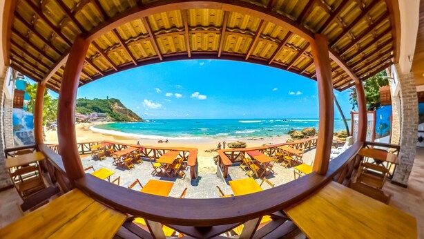 A beachside restaurant with outdoor seating and a view of the ocean. - Pousada Marinheiro (Cairu)