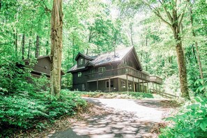 Eine Hütte mit Veranda, umgeben von dichtem Wald.