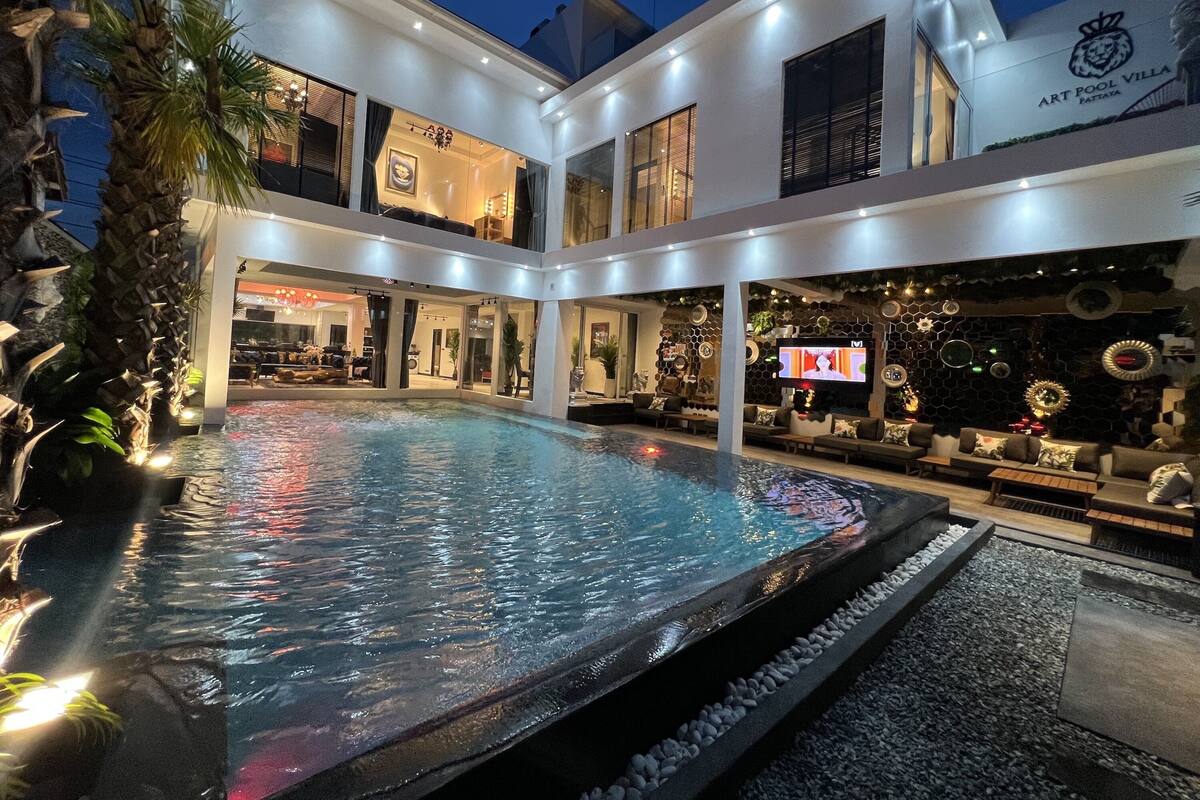 Une villa moderne dotée d’une piscine, de plusieurs balcons et d’un coin repas.