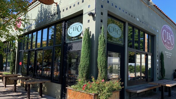 A CIBO bar and restaurant with large windows, outdoor seating, and a planter with flowers. - Jewel in the Sky:   Modern, Private,  Luxurious Loft + EV Charger! (Portland)
