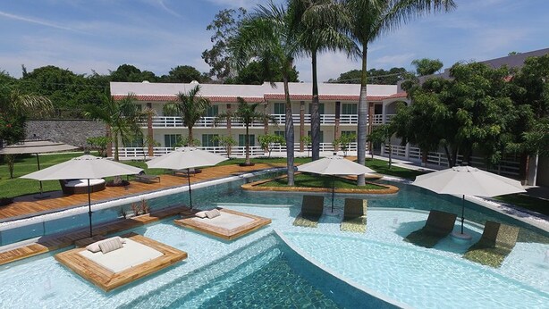 A swimming pool with lounge areas and palm trees. - El Laurel Hotel Boutique (Xochitepec)