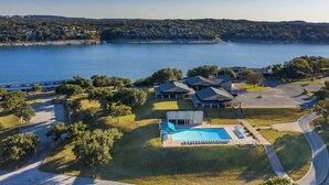 A lakeside property with a swimming pool, a covered patio, and a view of the lake. - Cozy Waterfront/Amazing Views/"Paradise Point" in Point Venture! (Leander)