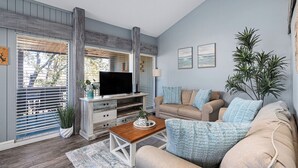 A living room with a TV, sofa, and coffee table. - Cozy Waterfront/Amazing Views/"Paradise Point" in Point Venture! (Leander)